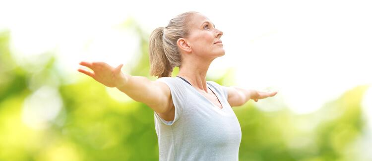 Woman smiling & stretching  her hands under the sun