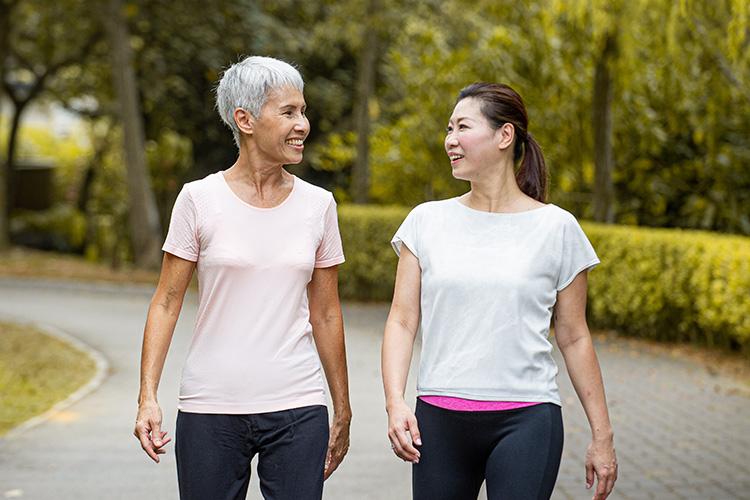 Cancer patient Rosemary with a friend walking in the park 