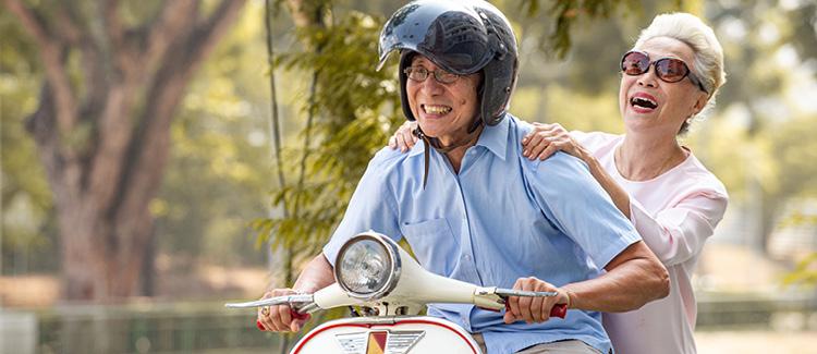 Elderly couple on a vespa driving