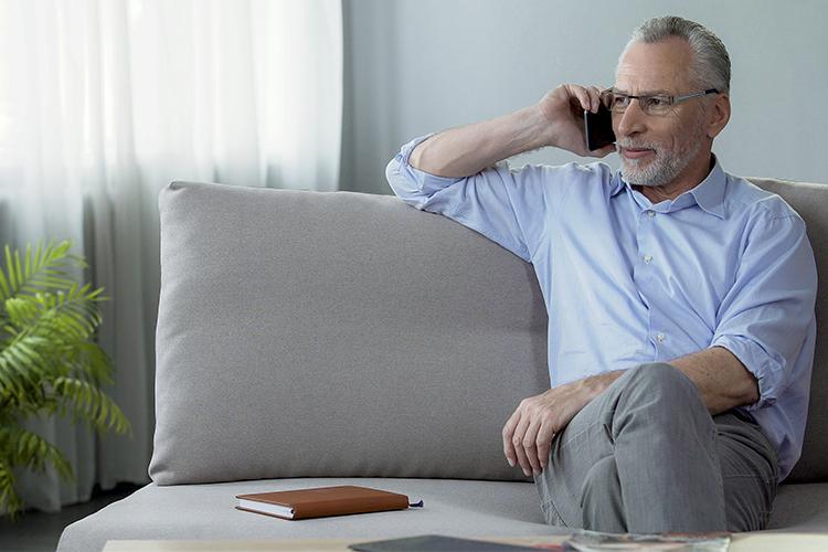 Mann auf einem Sofa telefoniert - verlinkt zu Kontakt 