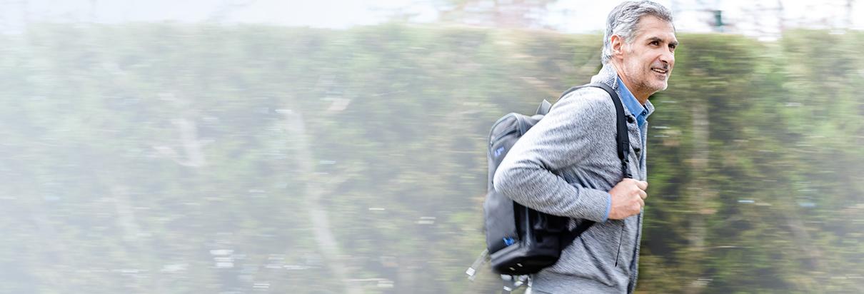 Man walking with tube feed backpack