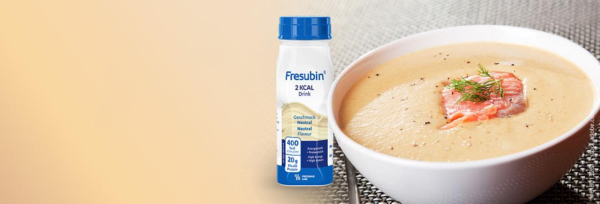 Kalte Spargelsuppe einer Suppenschüssel garniert mit Lachs, daneben die Fresubin Trinknahrung 2 KCAL Drink