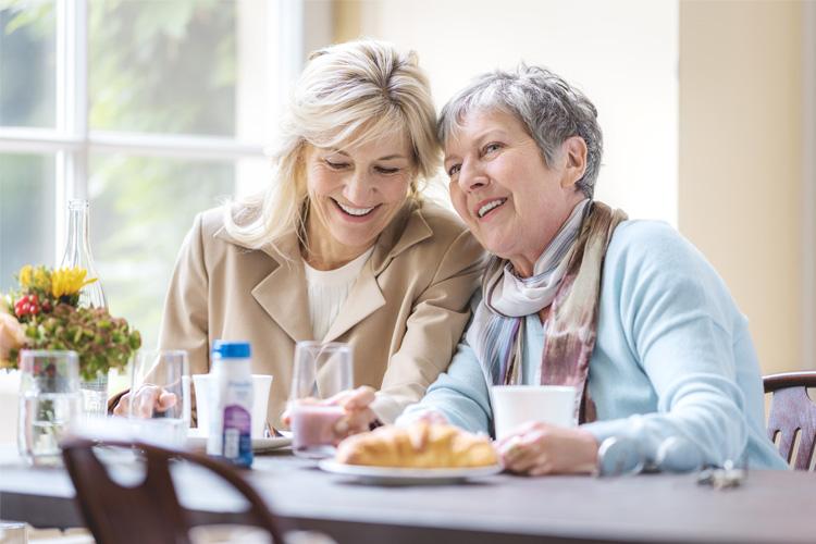 Patientin mit Dysphagie und Angehörige beim gemeinsamen Essen – Bei einer Schluckstörung ist es besonders wichtig, auf eine ausgewogene Ernährung zu achten