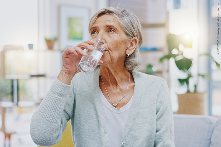Eine Patientin mit Schluckstörung trinkt ein Glas Wasser.
