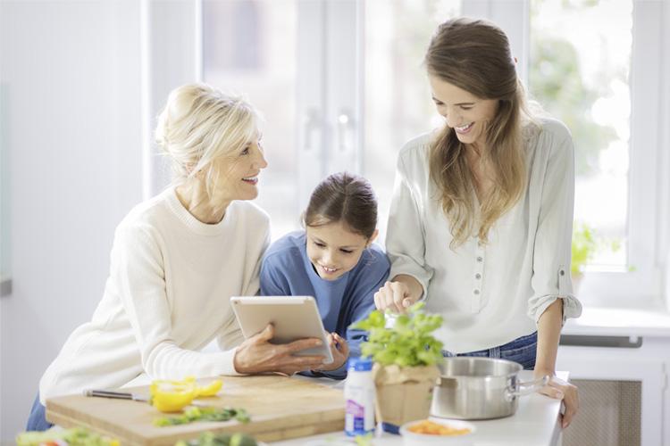 Ältere Patientin, Tochter und Enkelin schauen sich Rezepte auf Tablet an - verlinkt zu Ernährungstherapie