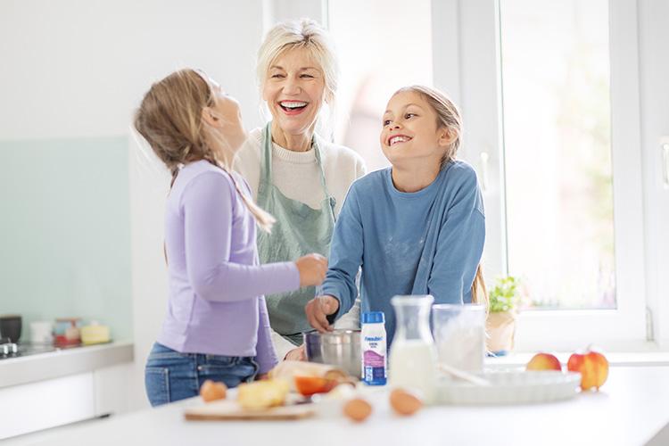 Patientin mit Enkelinnen beim gemeinsamen Backen - verlinkt zu Produktfinder