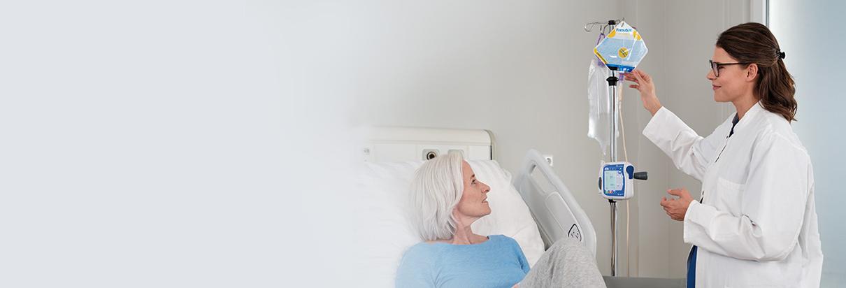 Produktfinder - Patientin im Krankenhausbett wird von einer Ärztin mit Fresenius Sondennahrung versorgt.