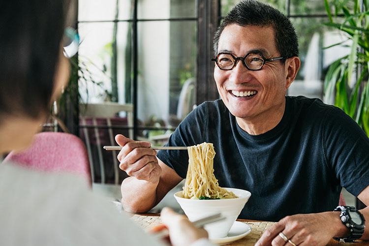 asian senior having dinner with a friend